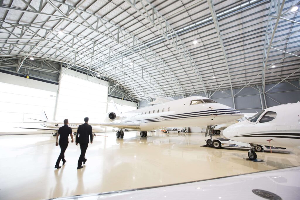 Men walking between light aircrafts