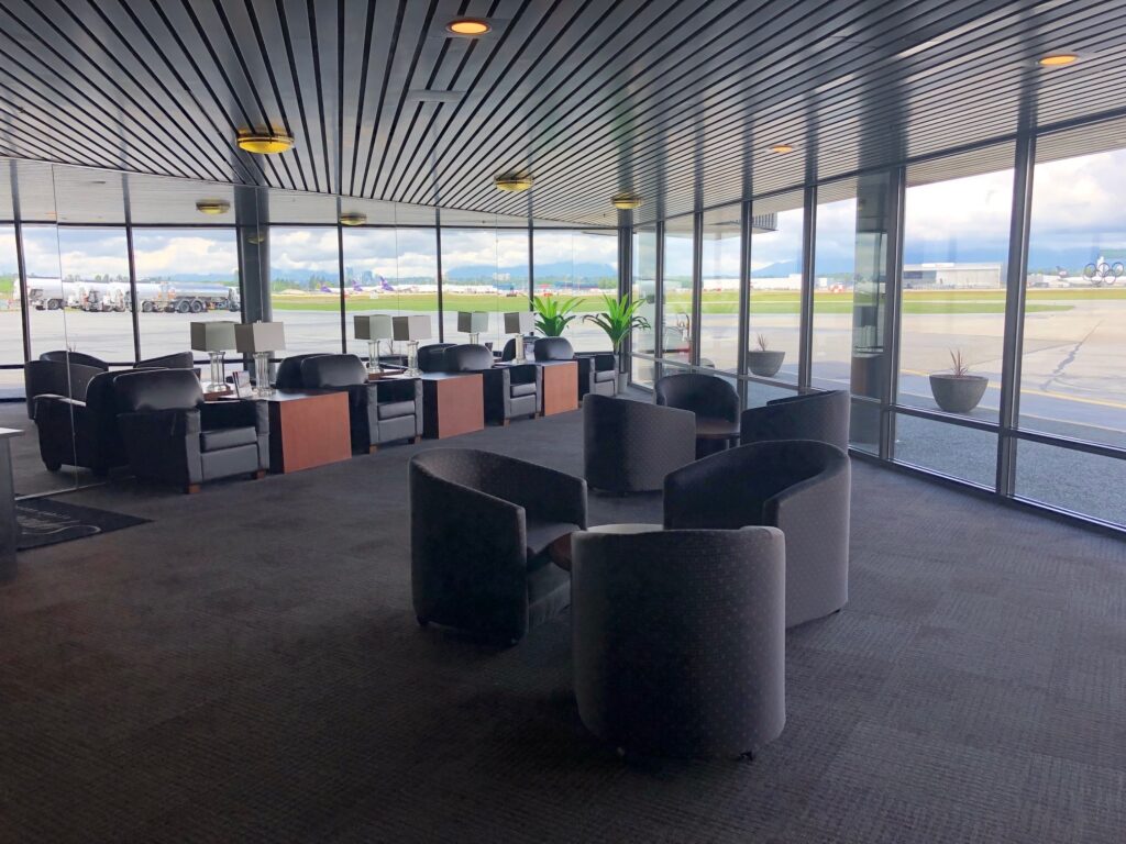 Armchairs and tables in the waiting room overlooking the runway