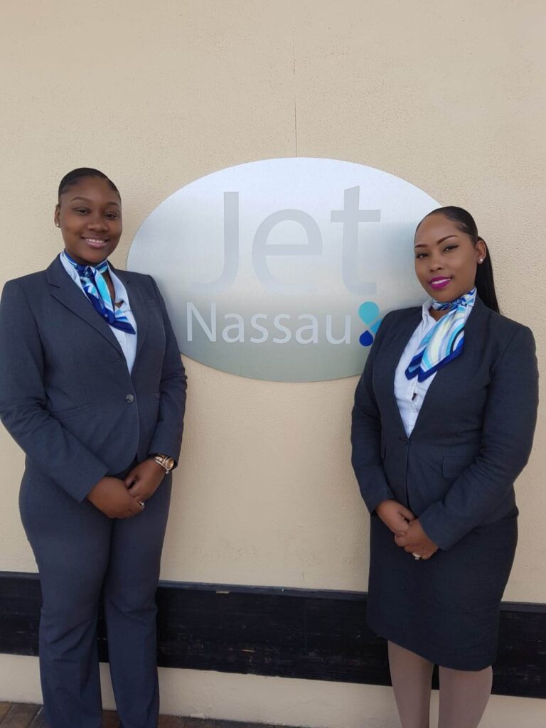 Two female crew members at the airport logo