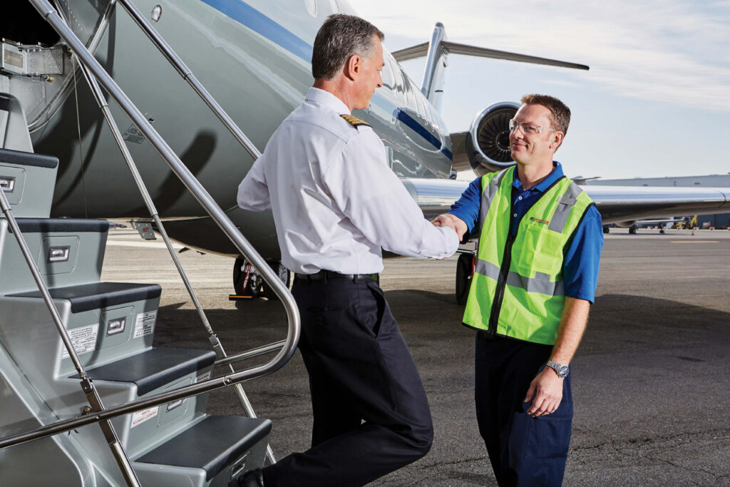 Pilot greeting with airport worker