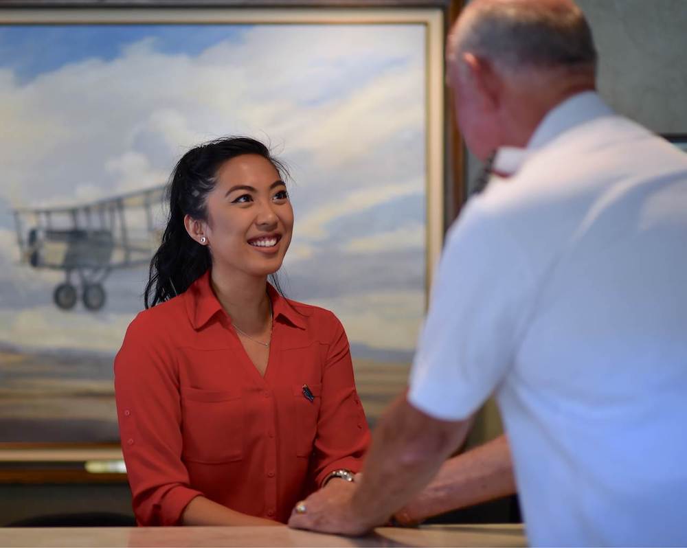 Female receptionist is smiling while serving a client