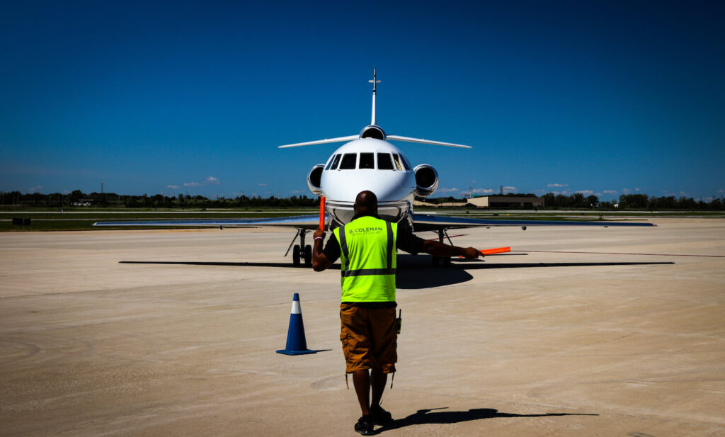 A line service man stands in front of the plane