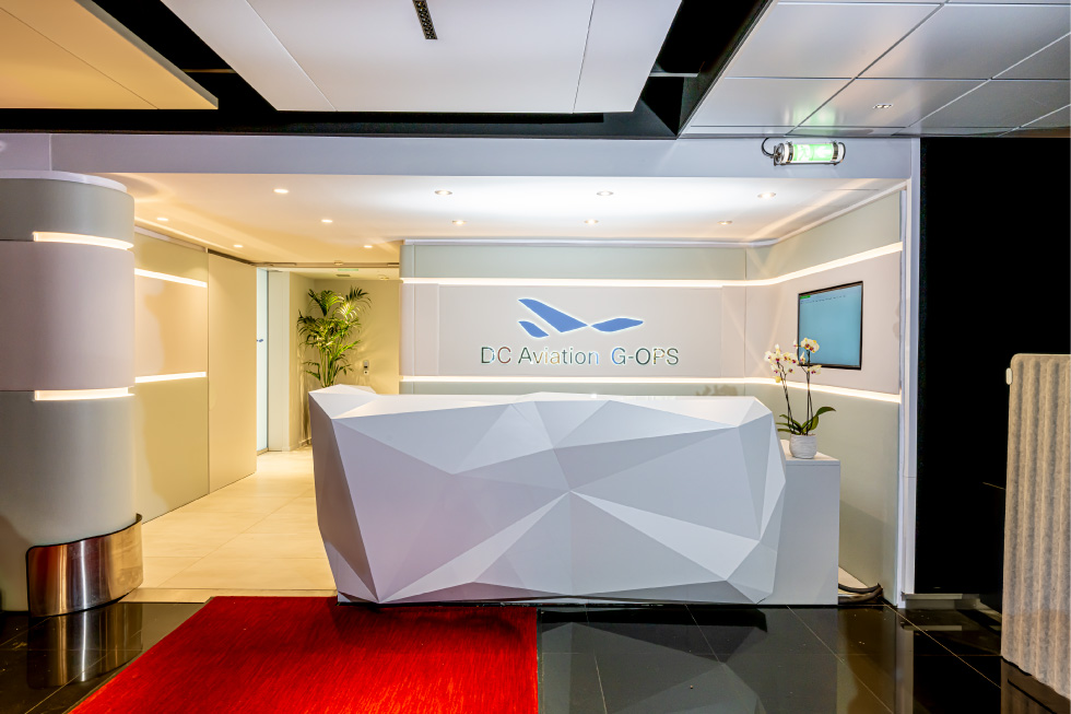 A receptionist desk with a red carpet leading up to it