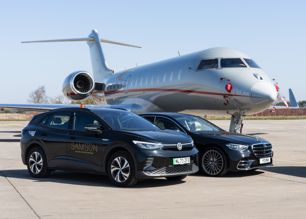 Samson vehicles on the runway next to an airplane